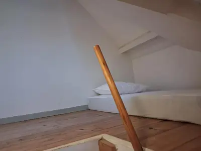 a wooden stick in a room with a bed at apart studio no3 in Kortenberg