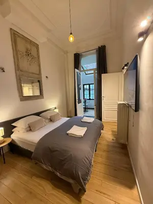 a bedroom with a large bed and a television at European Lodge Studio Brussels in Brussels