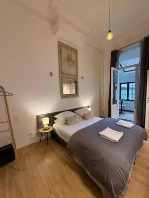 a bedroom with a large bed with two lamps on it at European Lodge Studio Brussels in Brussels