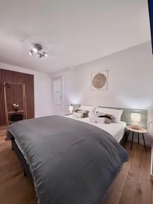 a bedroom with a large bed with white walls at European Lodge Rooms Brussels in Brussels