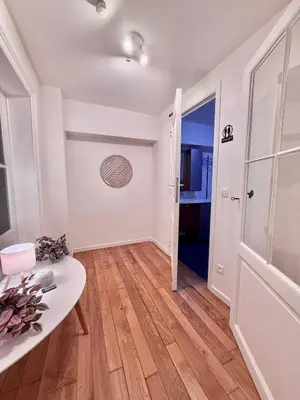 a living room with a wooden floor and white walls at European Lodge Rooms Brussels in Brussels