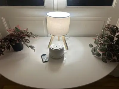 a table with a lamp and a cell phone on it at European Lodge Rooms Brussels in Brussels