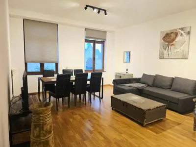 a living room with a couch and a table and chairs at Appartement Cozy Pauli 2 in Brussels