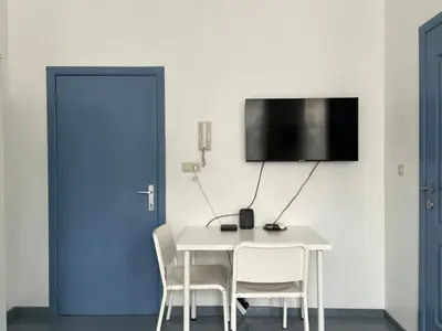 a room with a table and chairs and a blue door at Mini Urban Stay in Brussels