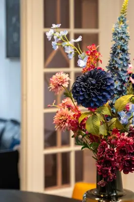 a vase filled with colorful flowers on a table at Inner-Homes in Antwerp