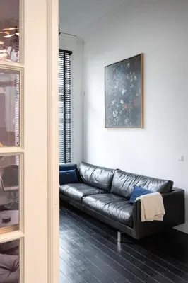 a black leather couch sitting in a living room at Inner-Homes in Antwerp