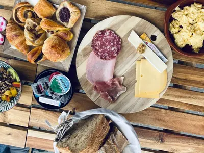 a wooden table topped with plates of bread and cheese at Casa Cava B&B in Dendermonde