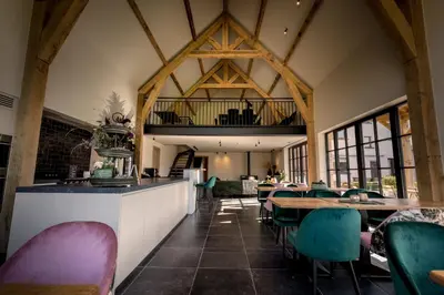 a dining room with tables and chairs in a building at Casa Cava B&B in Dendermonde