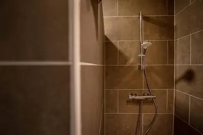 a shower with a shower head in a bathroom at Casa Cava B&B in Dendermonde