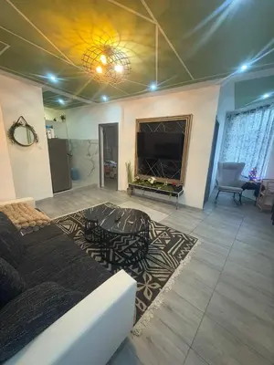 a living room with a large flat screen tv and a bed at Jps house in Brussels