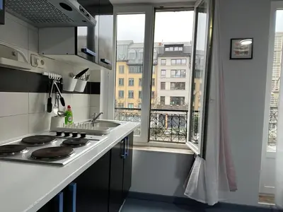 a kitchen with a stove top oven next to a window at Tiny Central Stay in Brussels