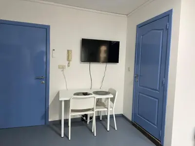 a room with a table and chairs and a blue door at Tiny Central Stay in Brussels