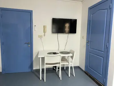 a room with a table and two chairs and a blue door at Tiny Central Stay in Brussels