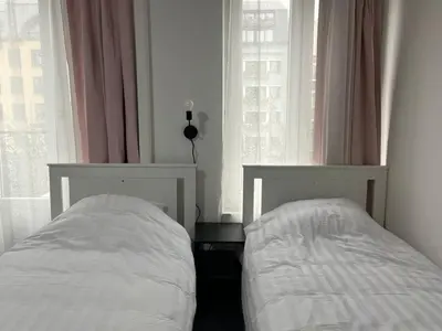 a bedroom with two beds and a window at Tiny Central Stay in Brussels