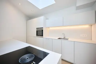 a white kitchen with white cabinets and a sink at Toison d'Or & saunna 2 in Brussels