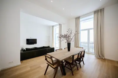 a living room with a table and a couch at Toison d'Or & saunna 2 in Brussels