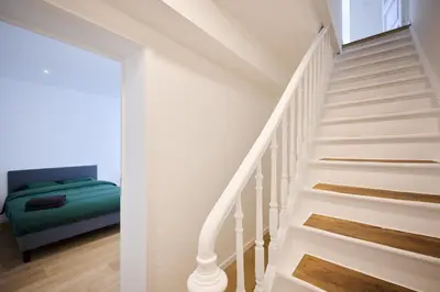 a white staircase with a green bed in a room at Toison d'Or & saunna 2 in Brussels