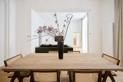 a wooden table with a vase with flowers on it at Toison d'Or & saunna 2 in Brussels