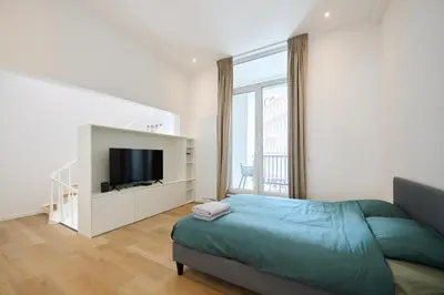 a bedroom with a bed and a flat screen tv at Toison d'Or House 4 in Brussels