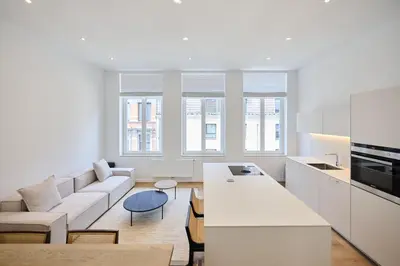 a white living room with a couch and a table at Toison d'Or House 4 in Brussels