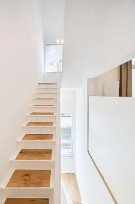 a staircase in a house with white walls and wooden floors at Toison d'Or House 4 in Brussels