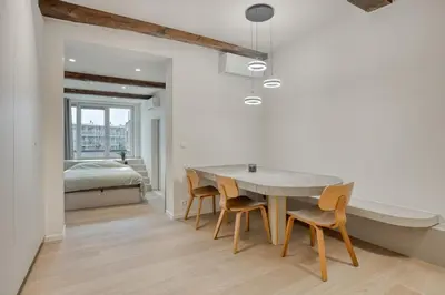 a dining room with a table and chairs and a bed at Cozy Stay in the Heart of Mechelen in Mechelen