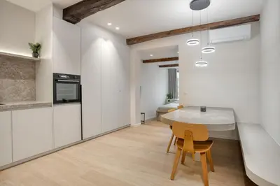 a kitchen with white walls and a table and a chair at Cozy Stay in the Heart of Mechelen in Mechelen