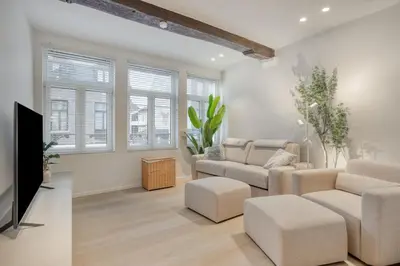 a living room with two couches and a flat screen tv at Cozy Stay in the Heart of Mechelen in Mechelen
