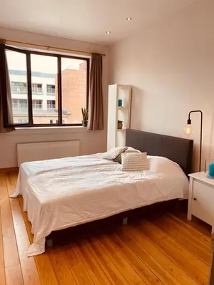 a bedroom with a large white bed with a window at Great apartment with a soul in the middle of the center in Ghent