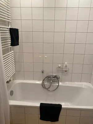 a white bath tub with a metal ring around it at Great apartment with a soul in the middle of the center in Ghent