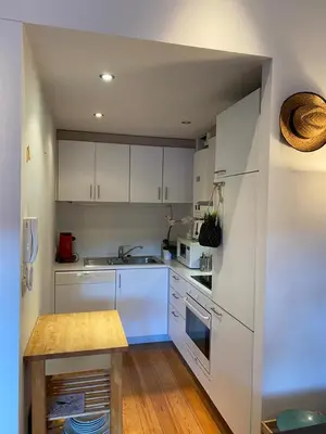 a kitchen with white cabinets and a wooden table at Great apartment with a soul in the middle of the center in Ghent