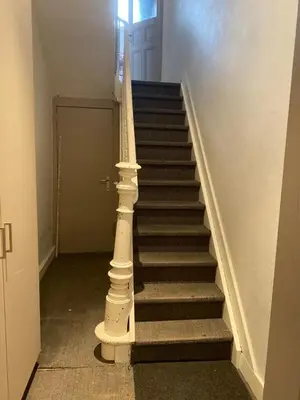 a staircase with a white column in a building at Great apartment with a soul in the middle of the center in Ghent
