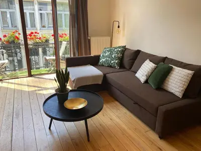 a living room with a couch and a table at Great apartment with a soul in the middle of the center in Ghent