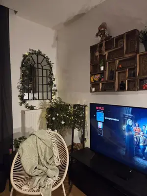 a living room with a tv and a chair with a blanket at Pb155, balcony with street view in Brussels