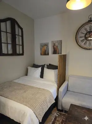 a bedroom with a bed and a chair and a clock at Pb155, balcony with street view in Brussels