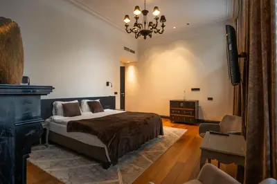 a bedroom with a bed and a television and a chair at Civiltà Boutique in Antwerp