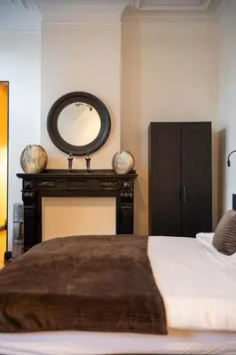 a bedroom with a bed with a mirror and a fireplace at Civiltà Boutique in Antwerp