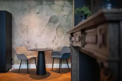 a table and chairs in a room with a fireplace at Civiltà Boutique in Antwerp