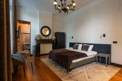 a bedroom with a large bed and a chandelier at Civiltà Boutique in Antwerp