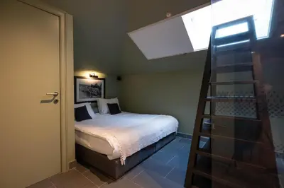 a small bedroom with a bed and a ladder at Civiltà Boutique in Antwerp