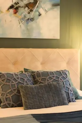 a bed with two pillows on it with a painting at Bed and Breakfast L'Orée Du Bois in Wavre