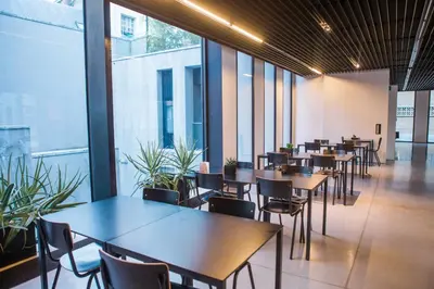 a restaurant with tables and chairs and large windows at Antwerp Central Youth Hostel in Antwerp
