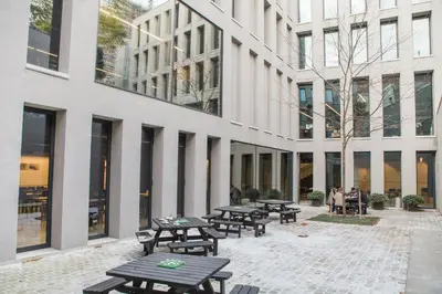a group of picnic tables in front of a building at Antwerp Central Youth Hostel in Antwerp