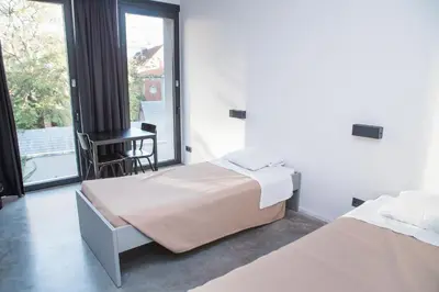 a bedroom with two beds and a desk and a window at Antwerp Central Youth Hostel in Antwerp
