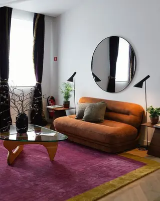 a living room with a couch and a mirror at A Place Antwerp - Boutique Suites & Flats - Schuttershofstraat 55 in Antwerp