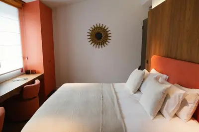 a bedroom with a white bed with an orange headboard at A Place Antwerp - Boutique Suites & Flats - Schuttershofstraat 55 in Antwerp
