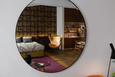 a mirror reflecting a room with a bed and a kitchen at A Place Antwerp - Boutique Suites & Flats - Schuttershofstraat 55 in Antwerp