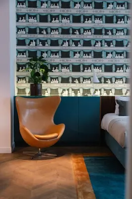 a room with a chair in front of a wall at A Place Antwerp - Boutique Suites & Flats - Schuttershofstraat 55 in Antwerp