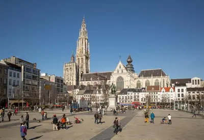 a group of people walking around a city with a cathedral at GuestHouse Groenplaats in Antwerp