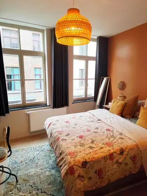 a bedroom with a bed and a chandelier at Cozy Renovated Studio in Central Brussels in Brussels